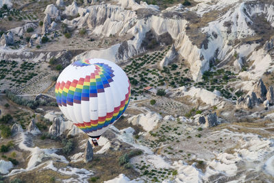 High angle view of hot air balloon over rock formations at cappadocia