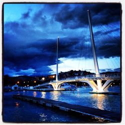 Bridge over river against cloudy sky