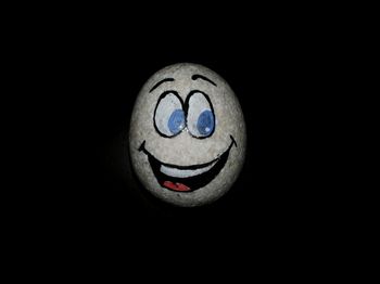 Close-up of smiley face against black background