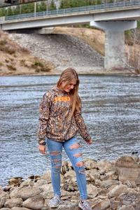 Woman standing on rock by water