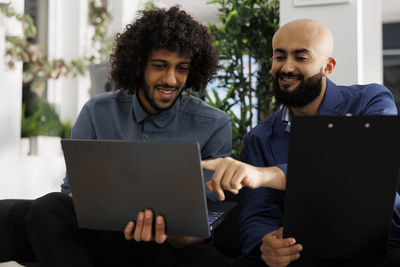 Portrait of man using laptop at office