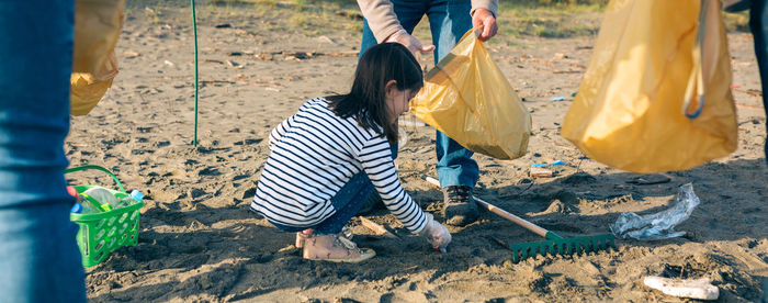 Girl picking up garbage at beach