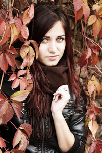 Portrait of young woman with autumn leaves