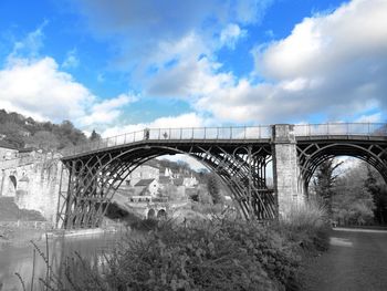 Arch bridge over river against sky