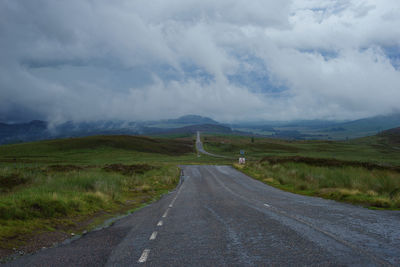 Road amidst green landscape against sky