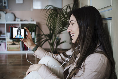 Woman photographing through smart phone at home