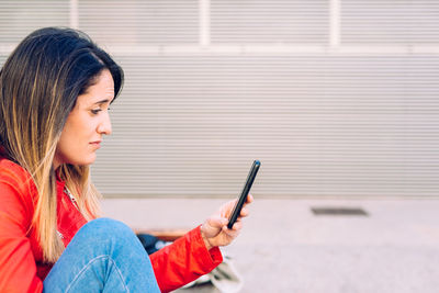 Side view of woman using mobile phone