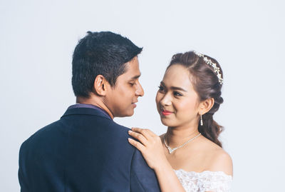 Portrait of couple kissing against white background