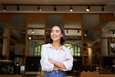 Portrait of young woman standing in store