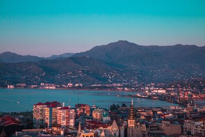 High angle view of townscape by mountains against clear sky