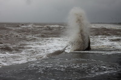 Water splashing in sea against sky