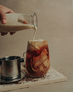 Close-up of hand pouring drink in glass