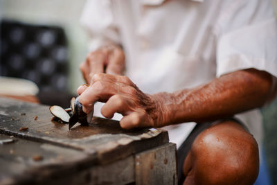 Close-up of senior man working on table