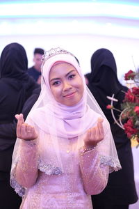 Portrait of bride in traditional clothing holding ring during wedding ceremony