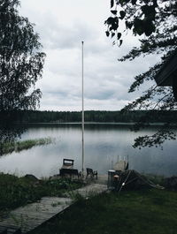 High angle view of empty bench and chair by lake