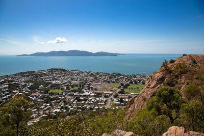 Aerial view of townscape by sea against sky