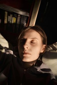 Portrait of young woman relaxing on bed at home