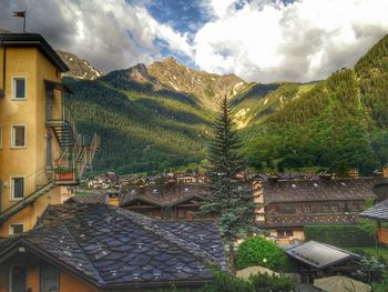 Houses by mountains against sky