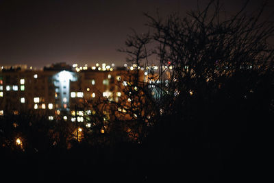 Illuminated city against sky at night