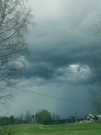 Storm clouds over grass against sky