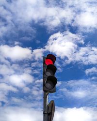 Low angle view of road signal against sky