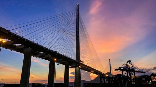 Low angle view of suspension bridge against sky during sunset