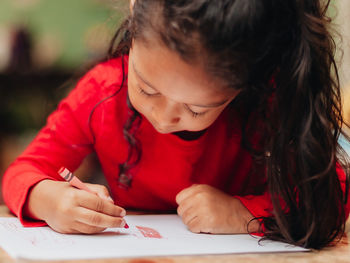 Close-up of girl looking away while sitting on table