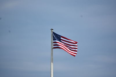 Low angle view of flag against blue sky
