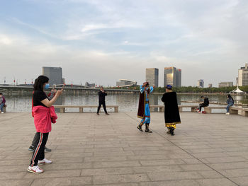 People standing in front of buildings against sky