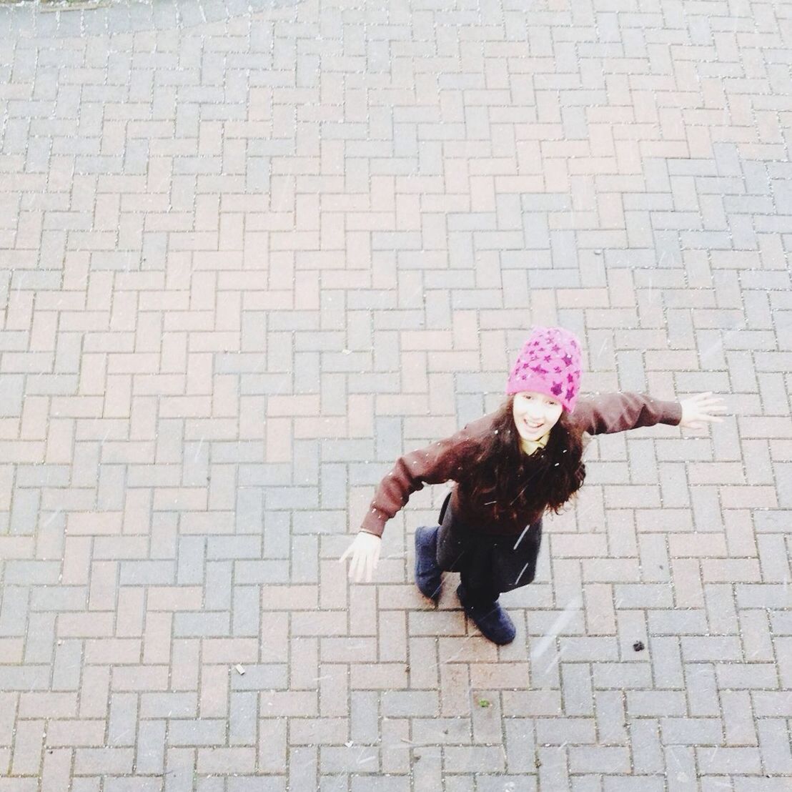 lifestyles, leisure activity, flower, full length, holding, casual clothing, high angle view, pink color, standing, childhood, person, girls, street, day, wall - building feature, outdoors, elementary age, shadow