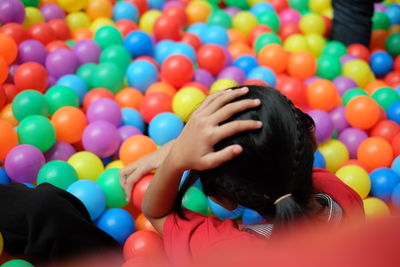 Close-up of boy with multi colored balloons