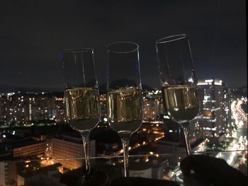 Close-up of champagne glass in city at night