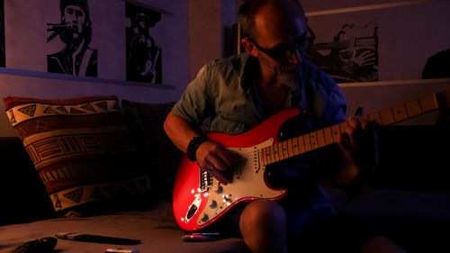 Man playing guitar at home