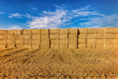 Scenic view of hay bales on harvested wheat field in provence against dramatic blue sky in summer