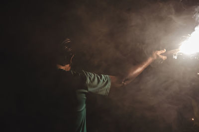Rear view of woman standing against black background