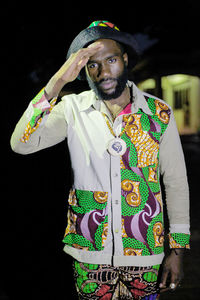 Young man standing against black background