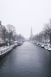 River amidst buildings in city against clear sky