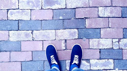 Low section of person standing on tiled floor