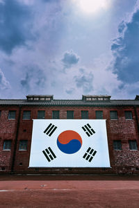Large korean flag on a brick wall on a cloudy day. 