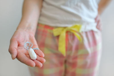 Midsection of woman holding tampon