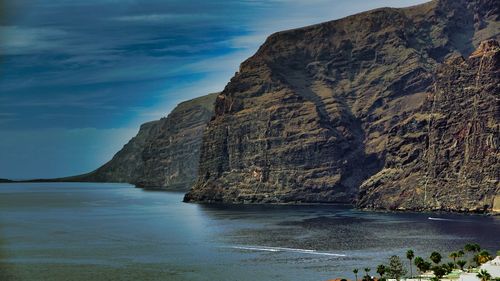 Rock formations by sea against sky