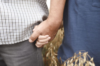 Grandfather holding grandson's hand, close-up