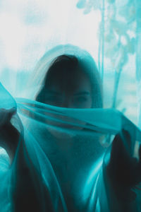 Portrait of woman seen through glass window