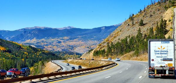 Road sign by mountains against blue sky