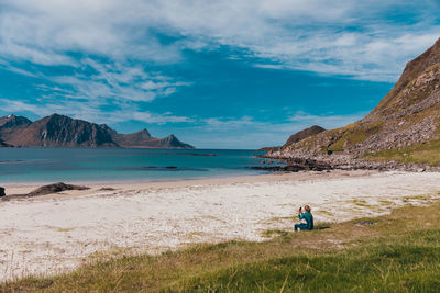 Rear view of people on beach against sky