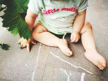 Low section of baby boy sitting on floor