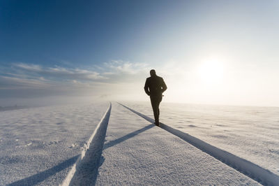 Teenager walking on snow against sky
