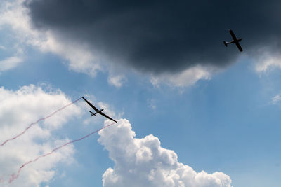 Low angle view of airplane in flight against sky