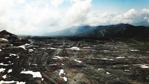 Scenic view of snow covered land against sky