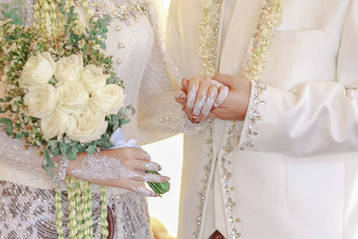 Midsection of woman holding flower bouquet